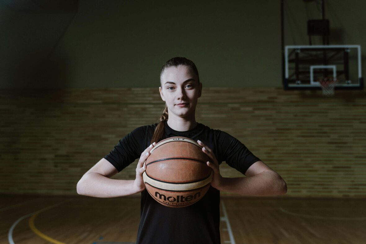 Woman Holding Basketball on Court
