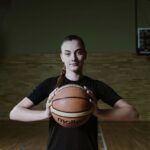 Woman Holding Basketball on Court