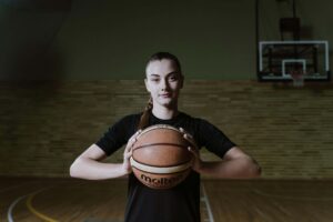 Woman Holding Basketball on Court