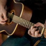 Person Playing Brown Guitar