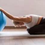 A woman doing yoga with yoga ball