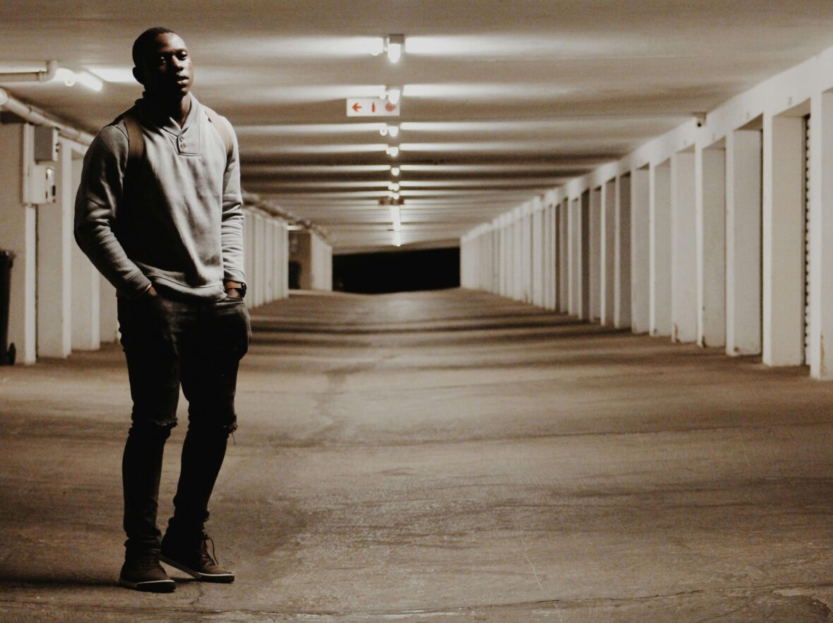 A Person Standing in Light Amidst Shadow