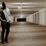 A Person Standing in Light Amidst Shadow