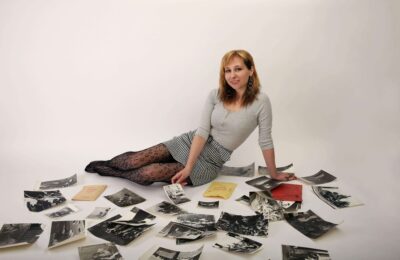 A women sitting on floor along with her past picture spread on floor